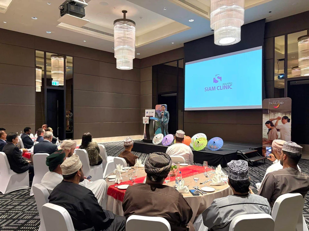 Siam Clinic presentation at Oman Health 2025 event with audience seated in conference room.