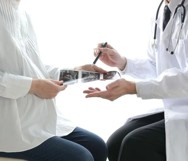A healthcare professional showing an X-ray to a patient during a consultation.