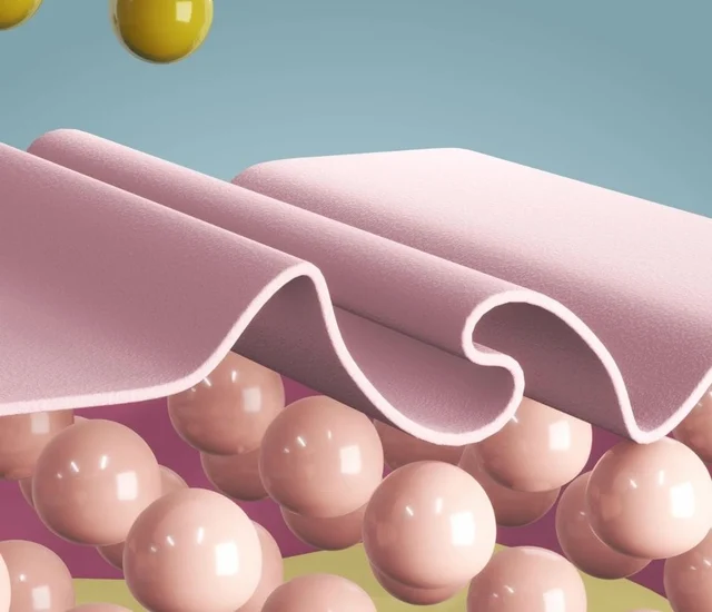 A soft pink fabric draped over a surface with pink spherical structures underneath.