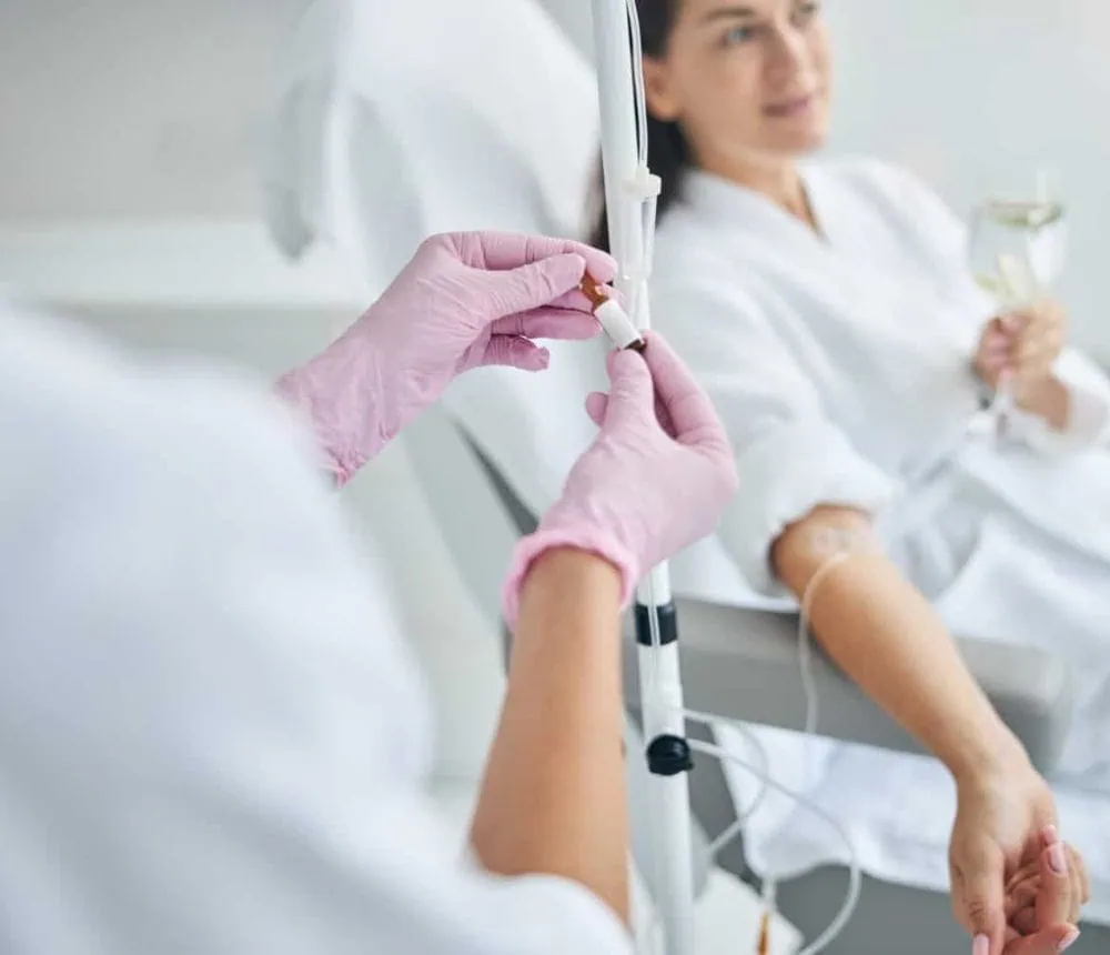 A person receiving an intravenous injection in a medical setting.