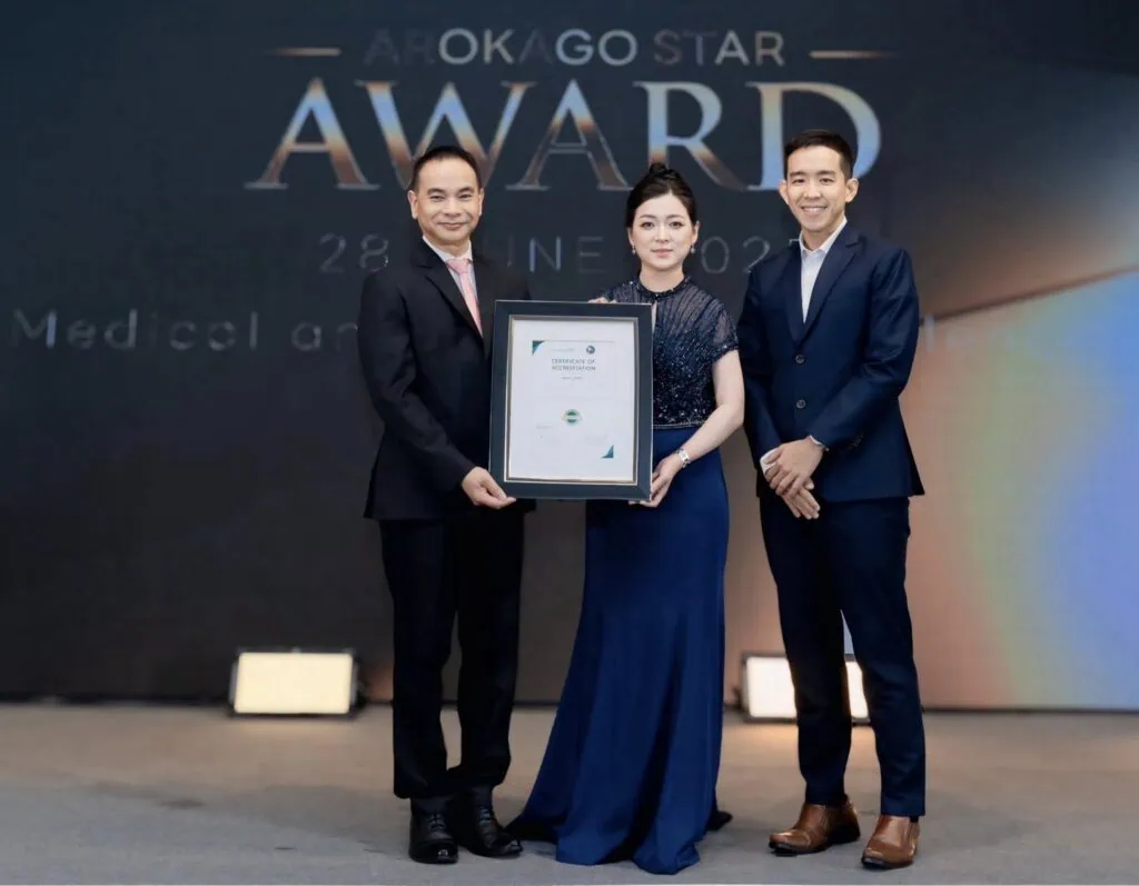 Siam Clinic team members holding a framed award on stage at the 2025 ArokaGO Star Award ceremony.