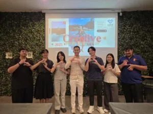 Creative team members posing in front of a presentation screen at a workshop.