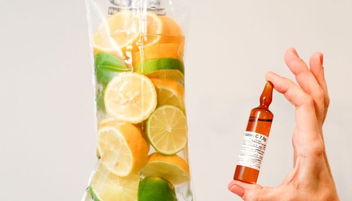 A clear plastic bag filled with lemon and lime slices hanging from hooks, with a hand holding a smal.