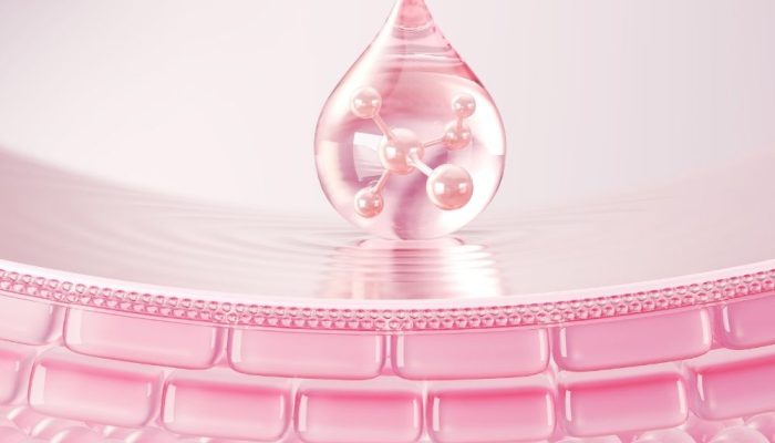 A drop of pink liquid with molecular structures above a textured pink surface.